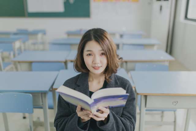 a young woman looking up from reading a book